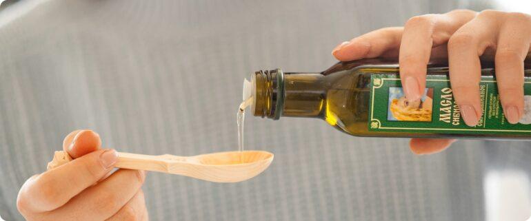 siberian pine nut oil pouring into wooden spoon